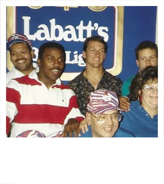 Vintage Polaroid picture of Labatt employees with a big "Labatt's Blue Light" sign in the background.